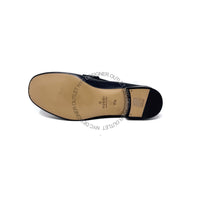 Navy blue loafer showing leather sole on a white background