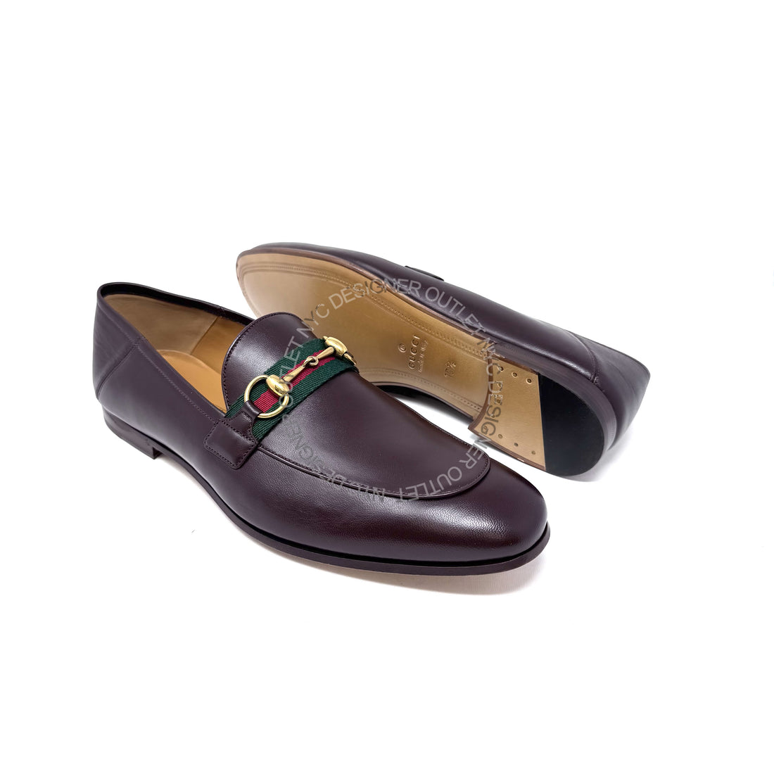 Brown loafers with a decorative strap on a white background