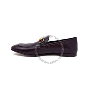 Black loafer shoe with a decorative buckle on a white background