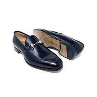 Pair of black loafers with a silver buckle on a white background