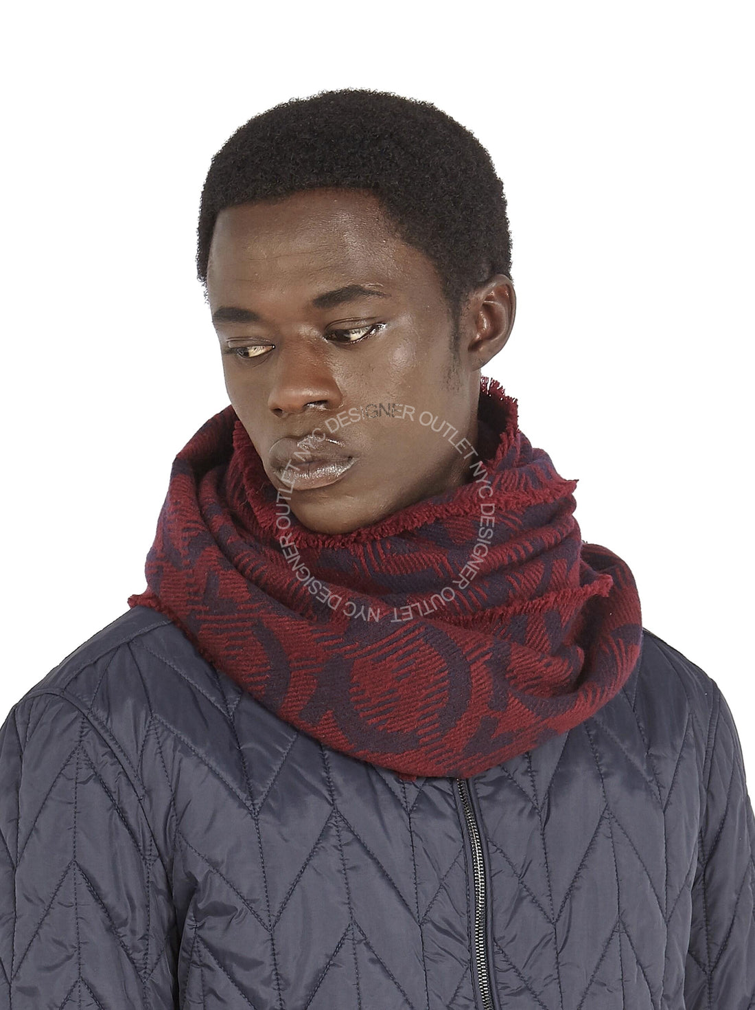 Person wearing a red patterned scarf and dark jacket on a white background