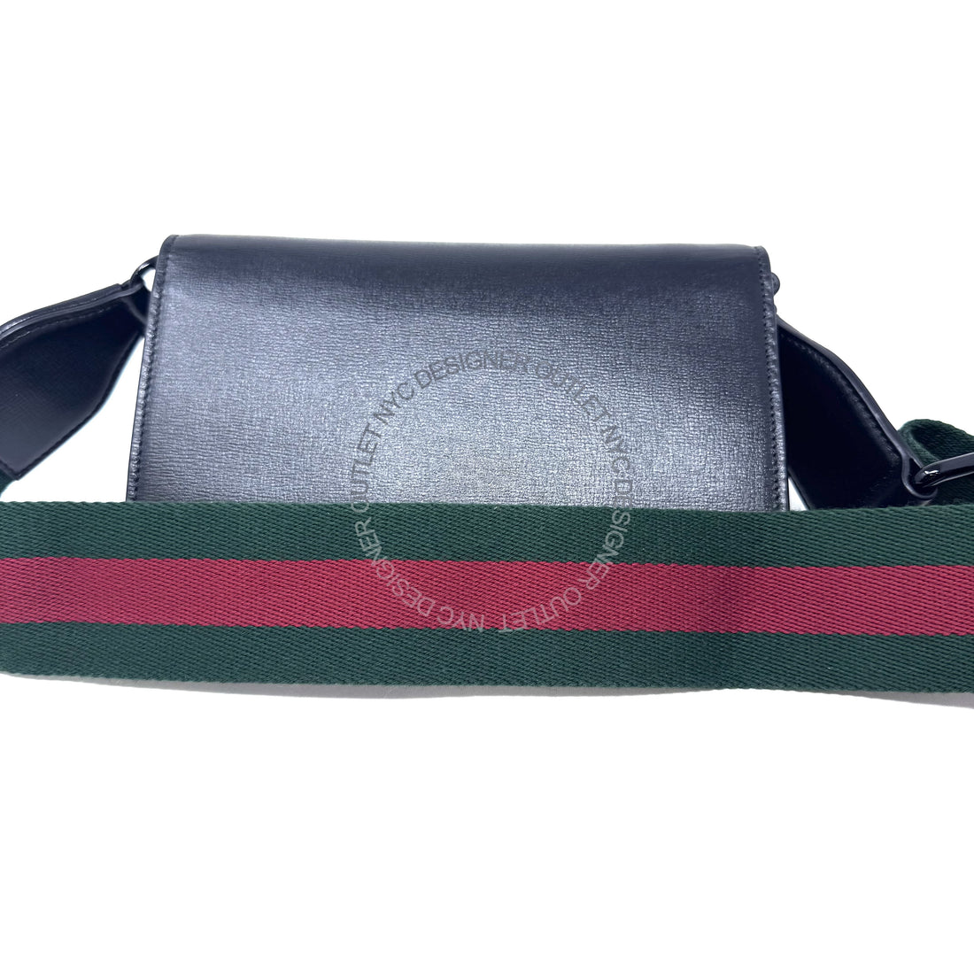 Black leather bag with a green and red striped strap on a white background